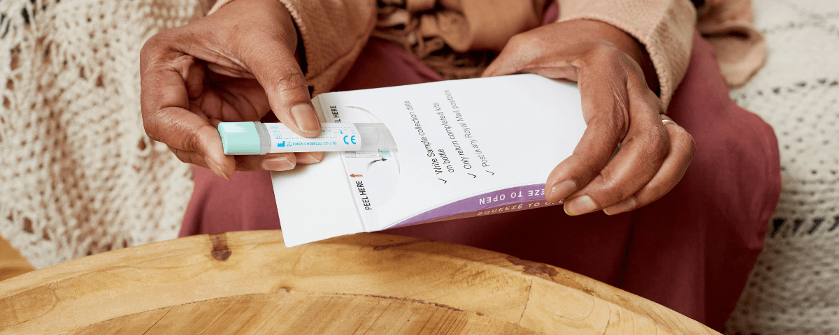 This photo shows a woman opening a Faecal Imunochemical Test.